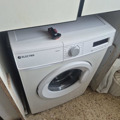 מכונת כביסה עם חפץ קטן עליה במטבח