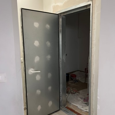 דלת מתכת פתוחה עם ידית לבנה