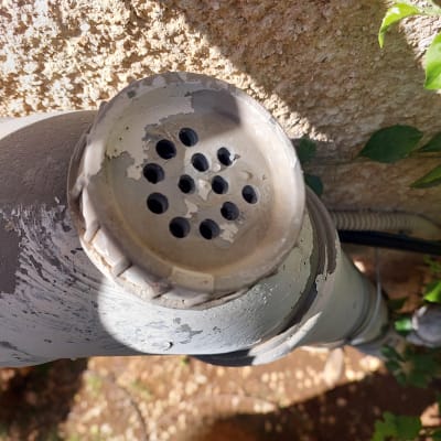 צינור מתכת עם מכסה מחורר על קיר