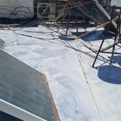 גג עם חומר איטום לבן ומיכלי מים