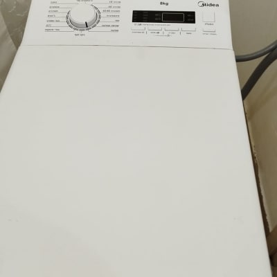 מכונת כביסה לבנה עם לוח בקרה וכפתורים