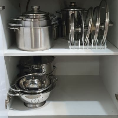 סירים ומכסים מסודרים בארון מטבח