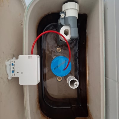 מיכל מים עם חלקי אינסטלציה וצינור אדום