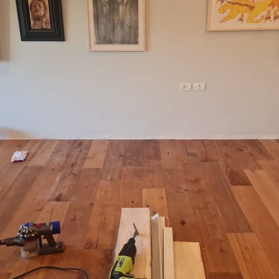 רצפת פרקט עם כלי עבודה ודלי צבע