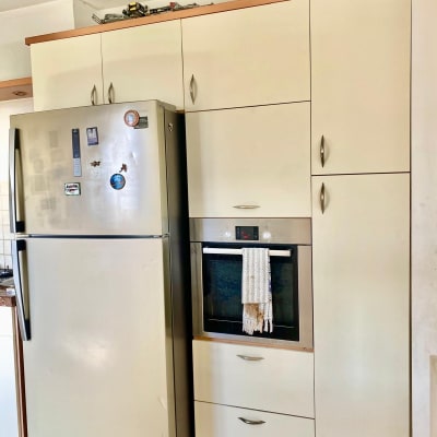 מקרר ותנור במטבח מודרני עם ארונות לבנים