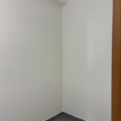 קיר צבוע בלבן עם רצפת אריחים אפורה