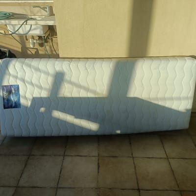 מזרן על רצפה עם צינור מים וכיור ברקע