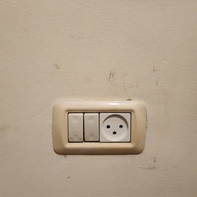 שקע חשמל עם שני מתגים על קיר