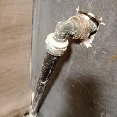 צינור מים מותקן בקיר עם חיבורי מתכת