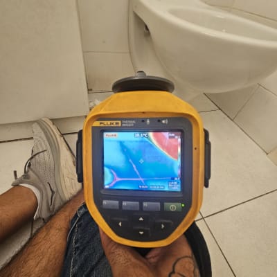 מד חום תרמי בשימוש ליד אסלה לבדיקת נזילות