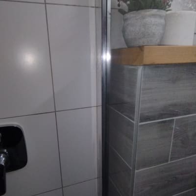 מקלחת עם אריחים לבנים וברז מתכת