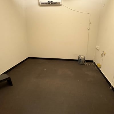 חדר ריק עם מזגן, דלי ושרפרף קטן