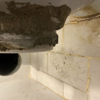 צינור ביוב עם לכלוך ונזילה על קיר אריחים