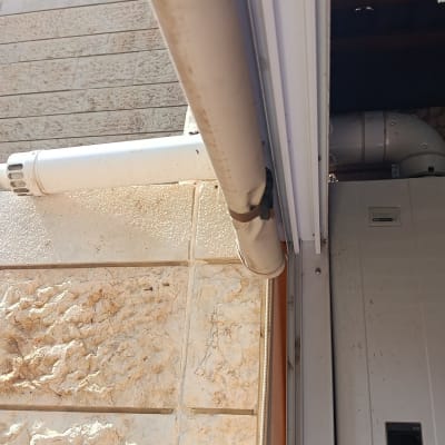 צינור ומכשיר על קיר חיצוני של בניין