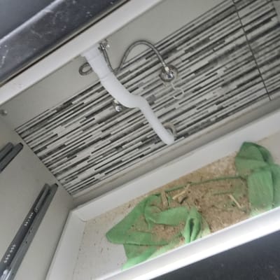 צינור פלסטיק לבן מתחת לכיור במטבח