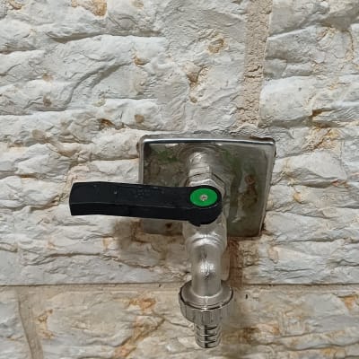 ברז מים מותקן על קיר אבן