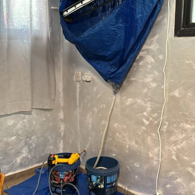 מזגן מפורק עם יריעת ניילון כחולה ודליים