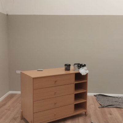 קירות צבועים, פחיות צבע על שידה, בד מגן על הרצפה