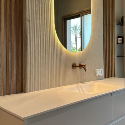 מראה עם תאורה מעל כיור בחדר אמבטיה מודרני