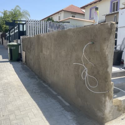 קיר בטון עם צינורות חשמל ברחוב מגורים