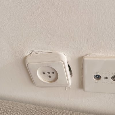 שקע חשמל בקיר עם חוטים חשופים
