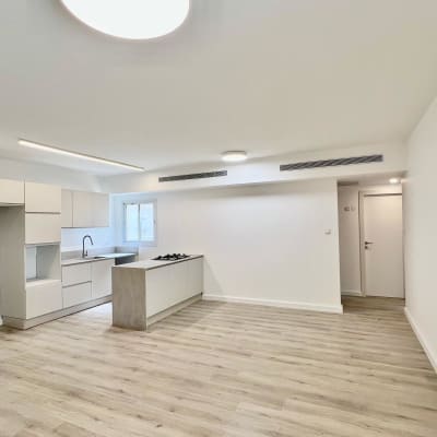 מטבח מודרני עם ארונות לבנים ומשטח עבודה אפור