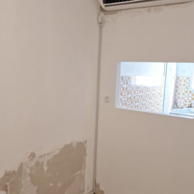 מזגן מותקן על קיר לבן עם תצוגת טמפרטורה