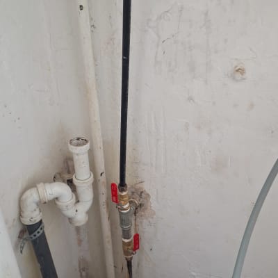 צינורות מים עם ברזים אדומים על קיר