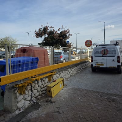 שער חשמלי צהוב עם רכב מסחרי חונה לידו