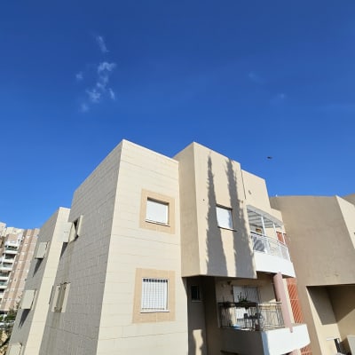 בניין מגורים עם שמיים כחולים ברקע