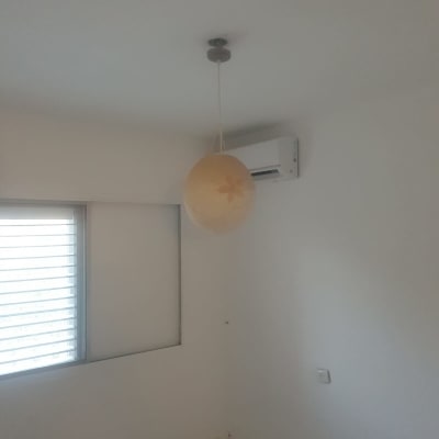 חדר עם קירות צבועים, מנורה ומזגן