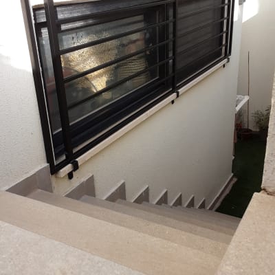 חלון עם מסגרת מתכת שחורה על קיר לבן