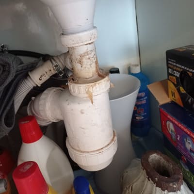 צינור ניקוז לבן מתחת לכיור עם חיבורים