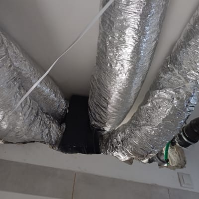 צינורות מיזוג אוויר מכוסים בבידוד כסוף בתקרה