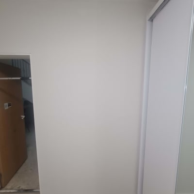 קיר צבוע בלבן עם דלת פתוחה בצד