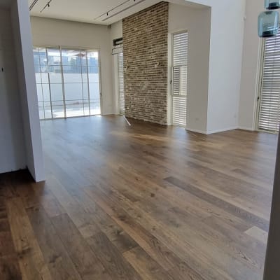 רצפת פרקט עץ כהה בחלל פנימי מואר