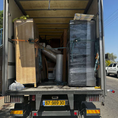 משאית הובלה עם רהיטים וארגזים קשורים