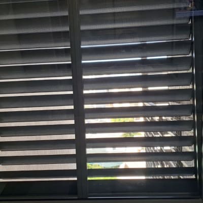 תריסים סגורים על חלון עם ידית בצד ימין