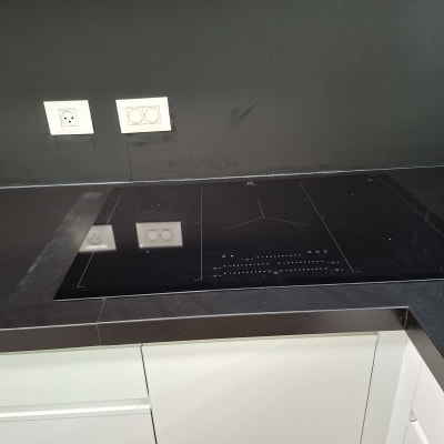 כיריים חשמליים על משטח עבודה כהה במטבח מודרני