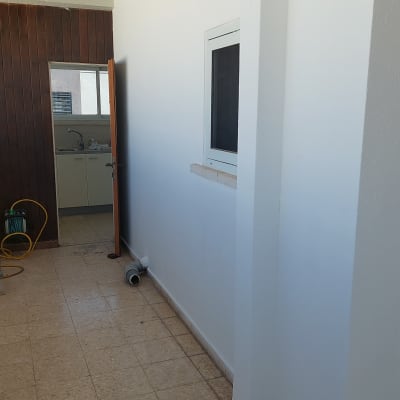 קיר צבוע במסדרון עם חלון ודלת פתוחה