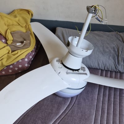 מאוורר תקרה מפורק עם חוטי חשמל חשופים על מיטה