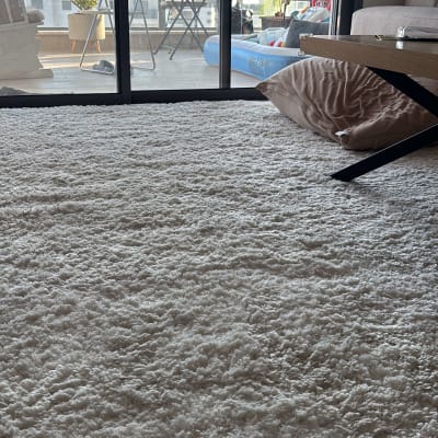 שטיח לבן על רצפה ליד חלון זכוכית גדול