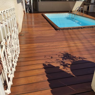 בריכת שחייה על דק עץ עם מעקה מתכת לבן