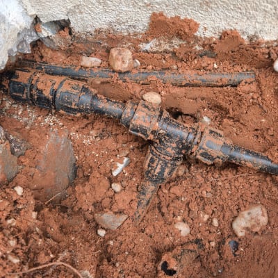 צנרת חשופה באדמה עם סימני נזילה