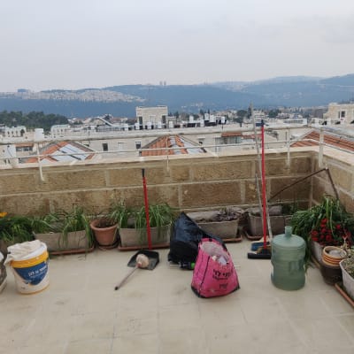 כלי עבודה ודלי על מרפסת עם נוף עירוני