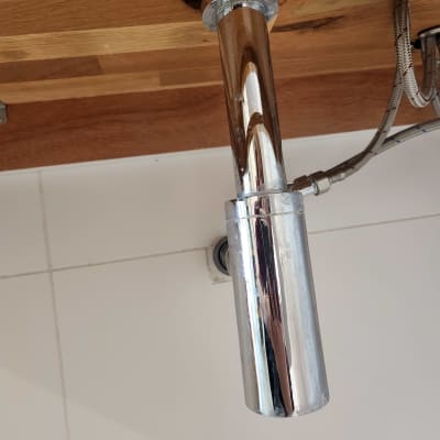 צינור מתכת מתחת לכיור עם חיבורים