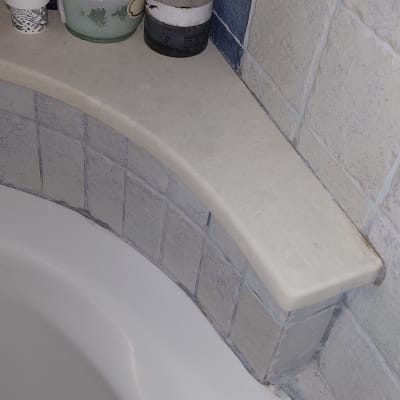 מוצרים על מדף באמבטיה עם אריחים כחולים