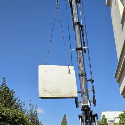 מנוף מרים לוח בטון ליד בניין