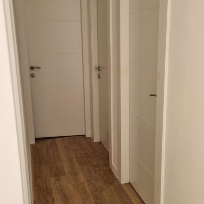 שלוש דלתות לבנות עם ידיות מתכת במסדרון