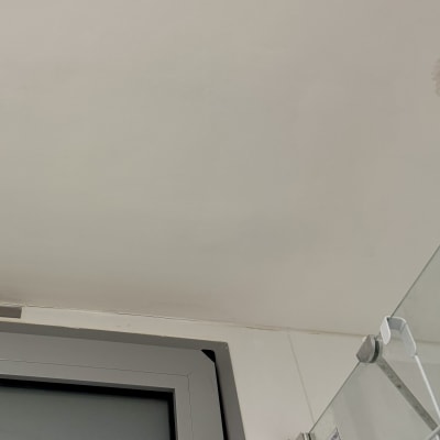 מסגרת חלון מתכתית ודלת זכוכית במקלחת